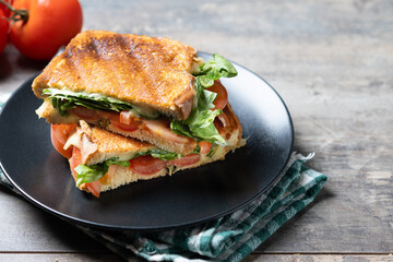 Healthy spinach, tomato and cheese sandwich on wooden table. Copy space
