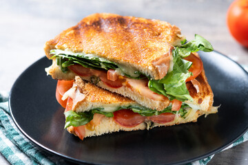 Healthy spinach, tomato and cheese sandwich on wooden table