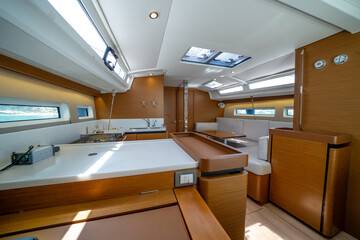 Sailing yacht interior. Double cabin on a charter yacht. Bareboat yacht interior - wood trim, light mattress and bedding, plenty of light from portholes. Comfortable berth for cruise on seas, oceans