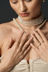 A young woman with pearl necklace and gold rings.