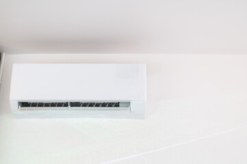 Close up view of a white air conditioning vent and a fire sprinkler on the ceiling, ensuring safety and comfort.