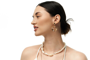 A young brunette woman with beautiful features showcases luxurious jewelry against a white backdrop.