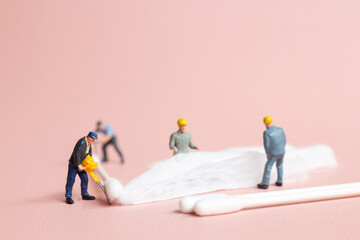 Worker in action, meticulously crafting a cotton bud from raw cotton.highlighting the delicate...