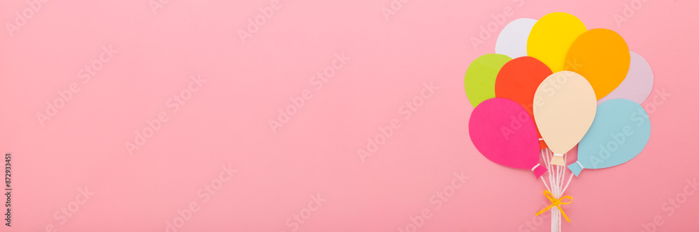 Wall mural bunch of colorful balloon shapes from application paper with white strings and ribbon on light pink 