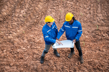 Two men in blue jackets are looking at a piece of paper
