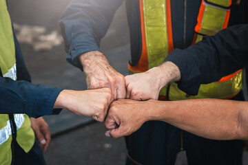 group of construction workers are fist bumping each other