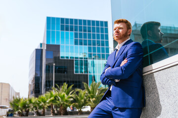 Pensive Businessman Posing with Arms Crossed in Business Park
