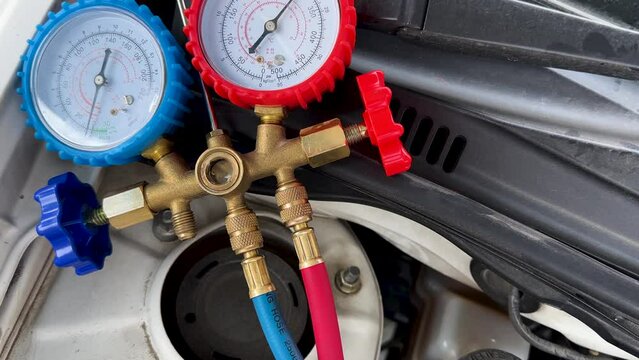 Mechanic Using A/C Manifold Gauge Set to Check Air Condition System