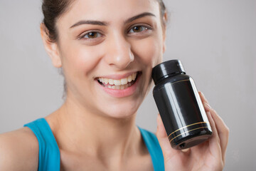 A Lovely Woman Showing Black Pills Bottle For Medical Advertisement Purposes