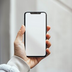  A smart mobile phone with a plain black white mock up screen being hand held, plain background for business info