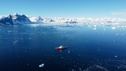 Fototapeta premium Large vessel in the Southern Ocean, Antarctica. Little boat in the big Ocean. Track from the boat in the frozen ocean