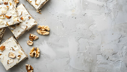 Pieces of delicious nutty nougat on light gray table, top view. Space for text