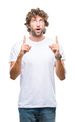 Fototapeta premium Handsome hispanic model man over isolated background amazed and surprised looking up and pointing with fingers and raised arms.