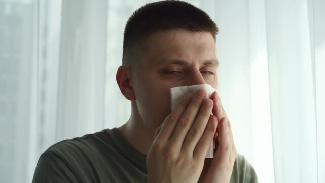 A man with a cold blows his nose into a napkin.
The man fell ill with the flu and had a severe runny nose.
Stuffy nose.