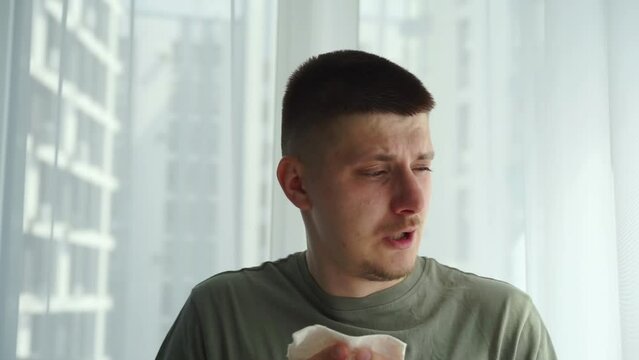 A man with a cold blows his nose into a napkin.
The man fell ill with the flu and had a severe runny nose.
Stuffy nose.