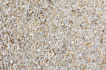 An assortment of diverse, small to medium-sized rocks and pebbles in a range of colors including grays, whites, and beiges, creating a natural and textured surface pattern.