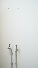 Place for installing an electric water heater boiler. Pipe leads and anchor fastenings on a white...