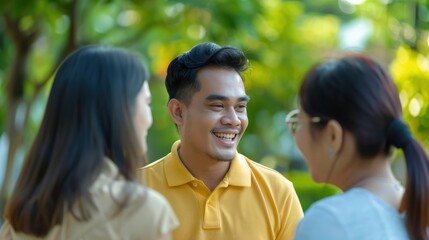 Excited and happy Indonesian male bank representative Explain their services to both customers. With the background of going to the park