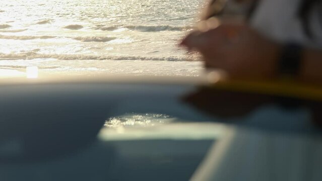 A young couple in an expensive yellow sports car on a sandy beach of the sea.