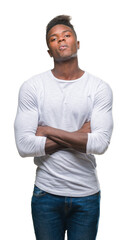 Young african american man over isolated background skeptic and nervous, disapproving expression on face with crossed arms. Negative person.