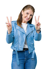 Beautiful middle age mature woman wearing fashion leather jacket over isolated background smiling looking to the camera showing fingers doing victory sign. Number two.