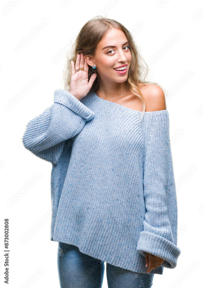 Poster Beautiful young blonde woman wearing winter sweater over isolated background smiling with hand over ear listening an hearing to rumor or gossip. Deafness concept.