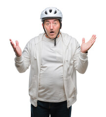 Handsome senior cyclist man wearing bike helmet over isolated background very happy and excited, winner expression celebrating victory screaming with big smile and raised hands