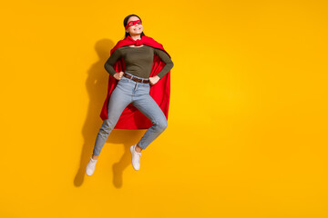 Full length photo of lovely teen lady look empty space superman flying dressed stylish khaki garment isolated on yellow color background