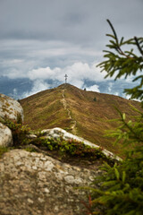 Fototapeta premium A Wooden Cross on a Mountain Peak in Cloudy Weather. Borzhava range during summer. Carpathian mountains, Ukraine