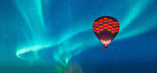 Hot air balloon flying over northern lights or aurora borealis