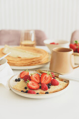 French homemade pancake crepes with berries. Summer breakfast.