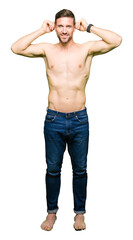 Fototapeta premium Handsome shirtless man showing nude chest Smiling pulling ears with fingers, funny gesture. Audition problem