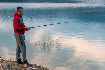 young man with fishing rode on the lake