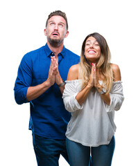 Young couple in love over isolated background begging and praying with hands together with hope expression on face very emotional and worried. Asking for forgiveness. Religion concept.