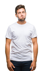 Fototapeta premium Young handsome man over isolated background puffing cheeks with funny face. Mouth inflated with air, crazy expression.