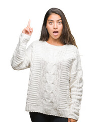 Young beautiful arab woman wearing winter sweater over isolated background pointing finger up with successful idea. Exited and happy. Number one.