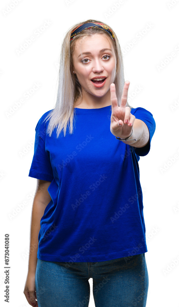 Poster young blonde woman over isolated background smiling with happy face winking at the camera doing vict