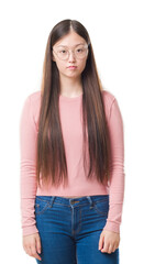 Obraz premium Young Chinese woman over isolated background wearing glasses with serious expression on face. Simple and natural looking at the camera.