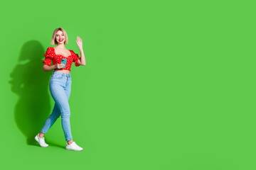 Photo of adorable lovely girl wear red trendy clothes hold samsung go empty space isolated on green color background