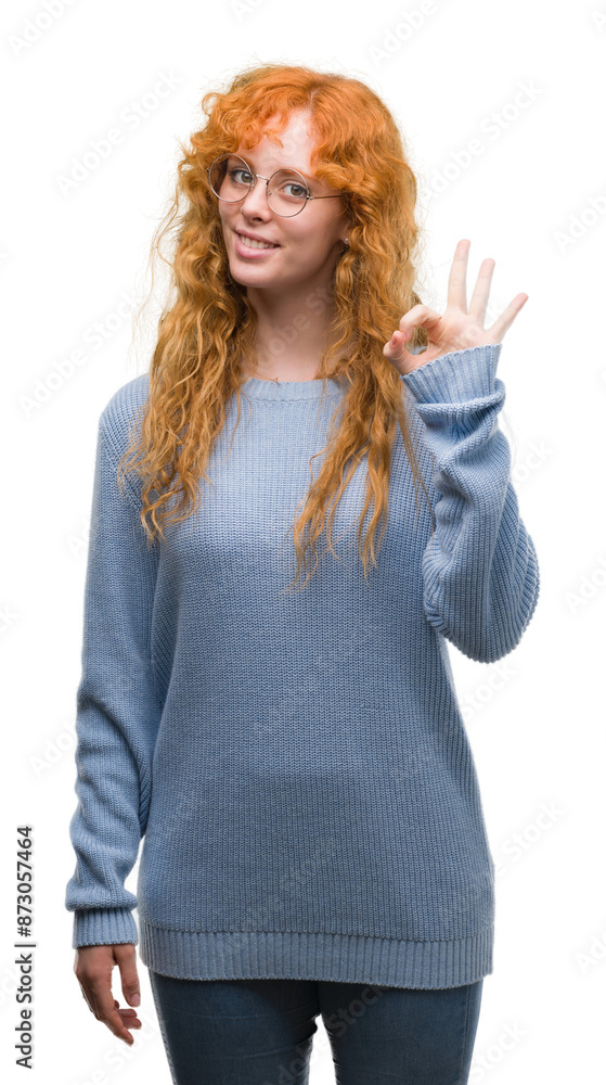 Wall mural young redhead woman wearing glasses doing ok sign with fingers, excellent symbol