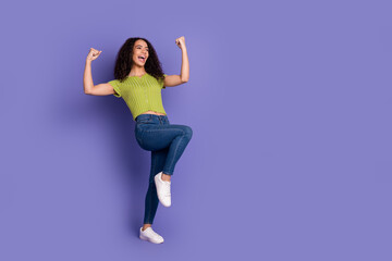 Full body photo of attractive teen woman celebrate winning dressed stylish green clothes isolated on purple color background