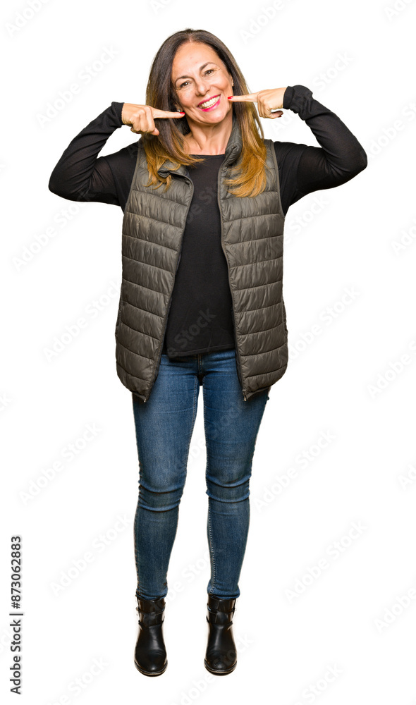 Wall mural beautiful middle age woman wearing winter vest smiling confident showing and pointing with fingers t