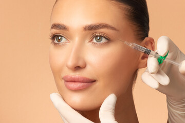 Beauty anti-wrinkle procedure. Beautiful young woman receiving hyaluronic acid injection,...