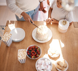 Birthday, child and mom cutting cake with celebration, sweets on table and happy event from above. Snacks, people and dessert at kids party for family love, bonding or fun gathering with care in home