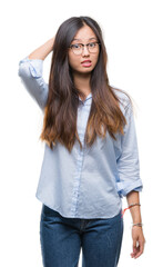 Obraz premium Young asian business woman wearing glasses over isolated background confuse and wonder about question. Uncertain with doubt, thinking with hand on head. Pensive concept.