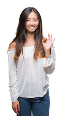 Young asian woman over isolated background smiling positive doing ok sign with hand and fingers. Successful expression.