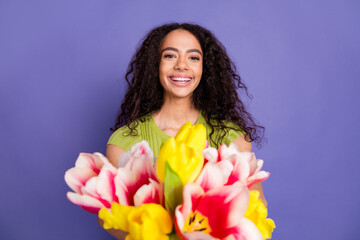 Fototapeta premium Photo portrait of pretty teen girl hold tulips flowers wear trendy green outfit isolated on purple color background