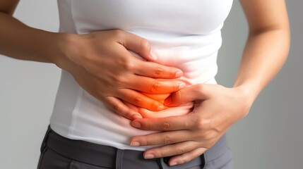 Woman holding her stomach in pain, experiencing abdominal discomfort.