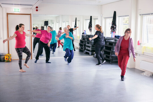 Group of women with disability exercising together in fitness studio