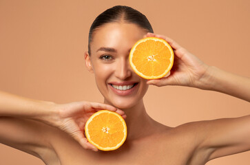 Natural vitamin C for skincare. Happy woman with organic slices of citrus fruits, dermatology or healthy wellness
